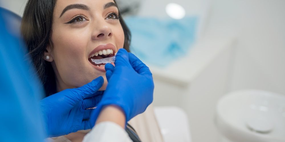 Dentist inserting retainers